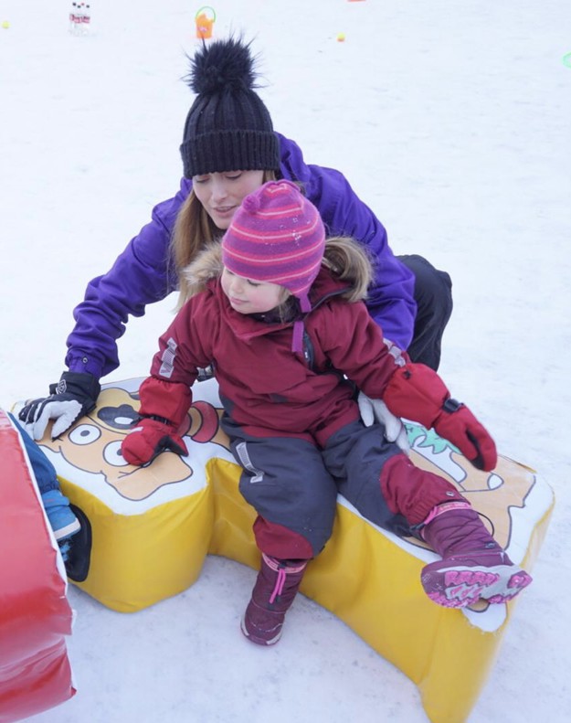 Irene Monetta with a small child, her daughter, dressed in thick clothes in the snow