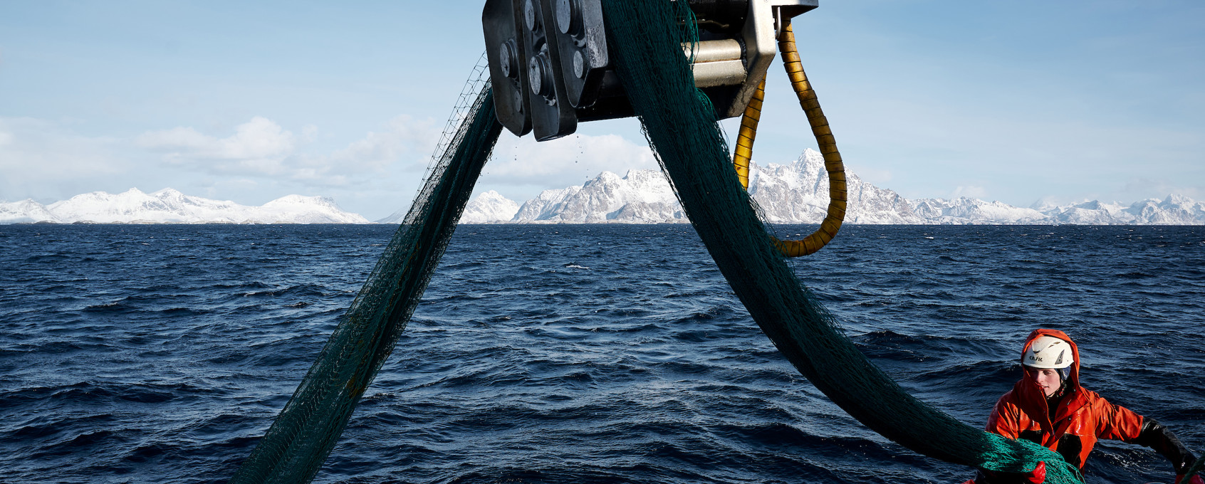 Fishing boats at sea with mountains in the background