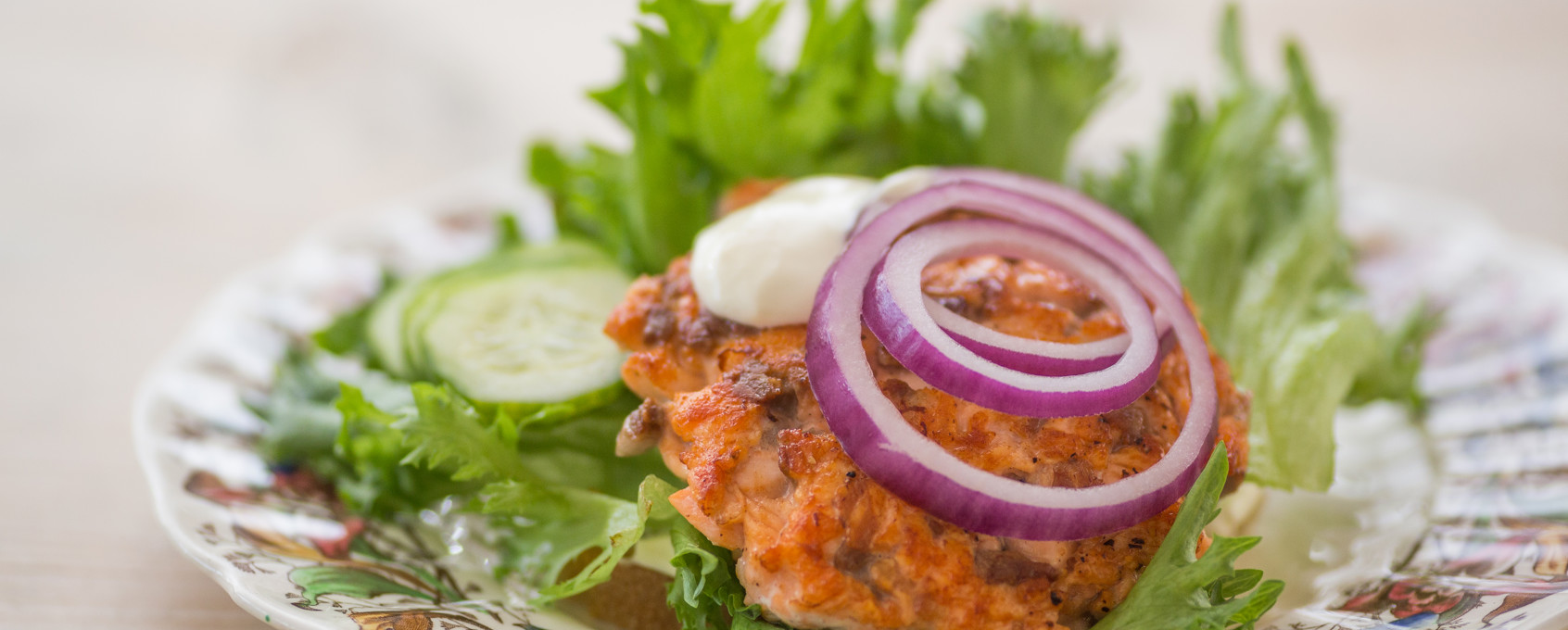 Hjemmelaget fiskeburger med rødløk og rømme
